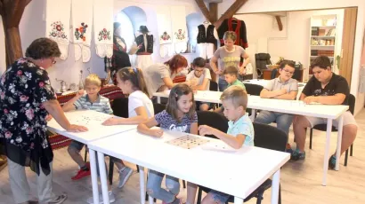 Djeca na radionici rade u grupama, a voditeljica radionice im predstavlja pojedina slova koja oni crtaju i tako uče/Foto: Nikolina Glodić