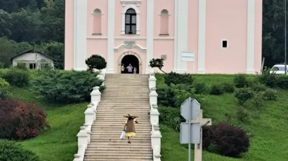 Žena s drvenim križem na leđima ispred crkve/Foto: Snimila čitateljica